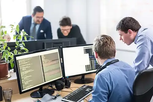 Personas en una oficina delante de la pantalla de un ordenador